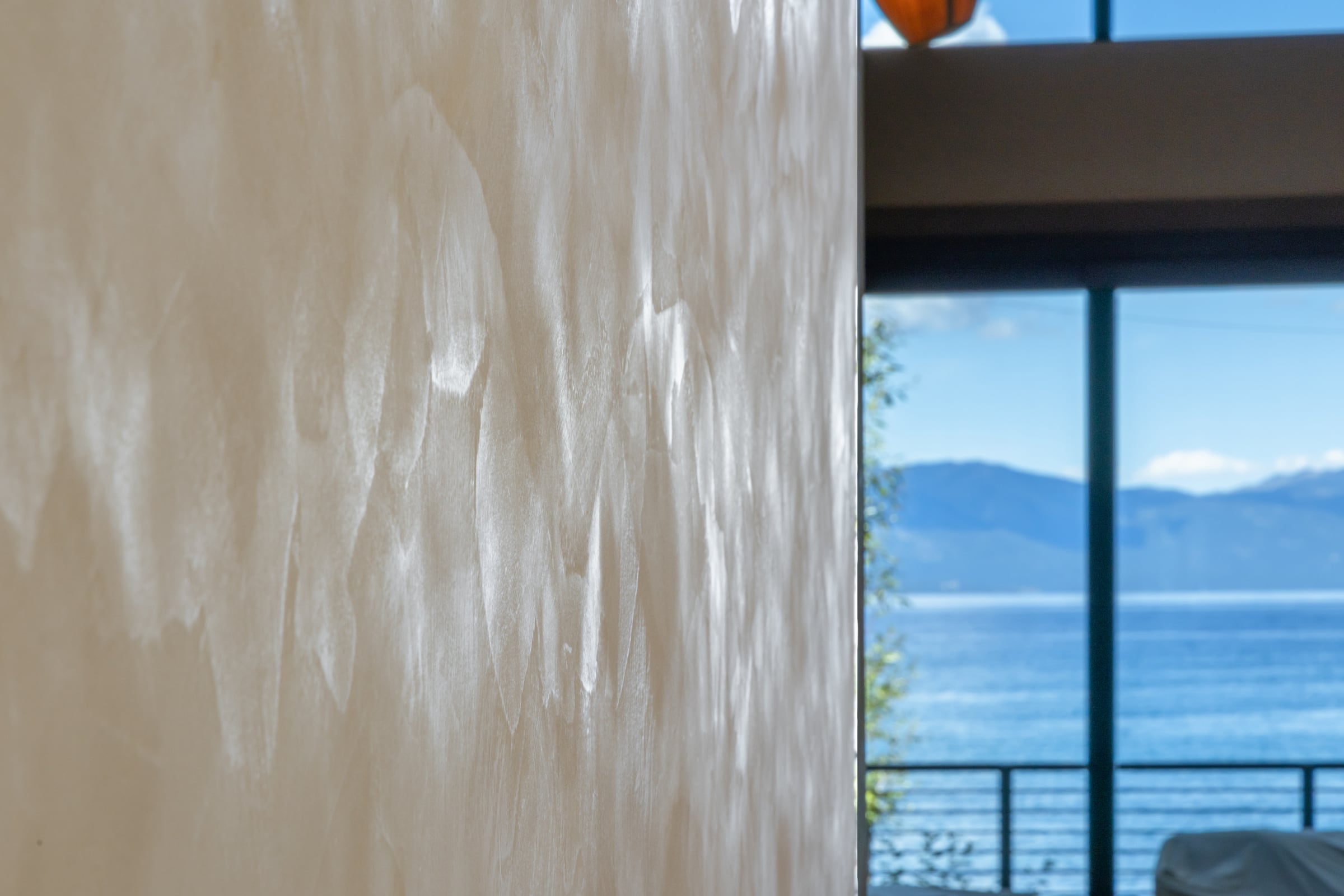 A polished plaster wall beside a window looking out over Lake Tahoe